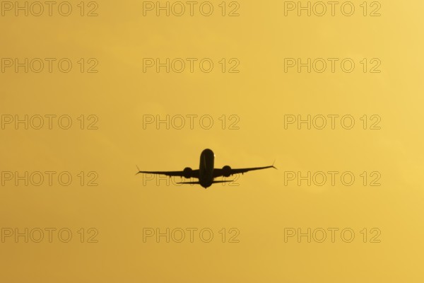 Airbus commercial passenger airliner jet aircraft taking off in flight silhouette at sunset at London Stansted airport, Essex, England, United Kingdom