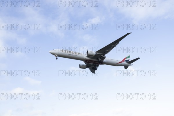 Boeing 777 commercial passenger airliner jet aircraft of Emirates airways in flight on approach to London Stansted airport, Essex, England, United Kingdom