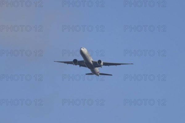 Boeing 777 commercial passenger airliner jet aircraft of Emirates airways in flight at London Stansted airport, Essex, England, United Kingdom