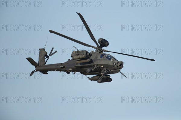 Hughes McDonnell Douglas Boeing AH-64 Apache helicopter of the British Army air corps flying in a blue sky, England, United Kingdom