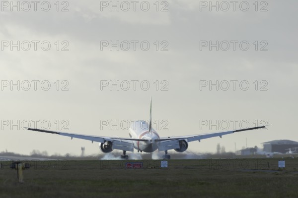 Boeing 777 commercial passenger airliner jet aircraft of Emirates airways landing on the runway at London Stansted airport, Essex, England, United Kingdom