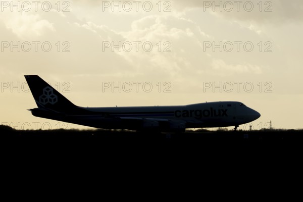 Boeing 747-400 jumbo jet LX-TCV commercial aircraft of Cargolux cargo waiting to take off silhouette at sunset at London Stansted airport, Essex, England, United Kingdom
