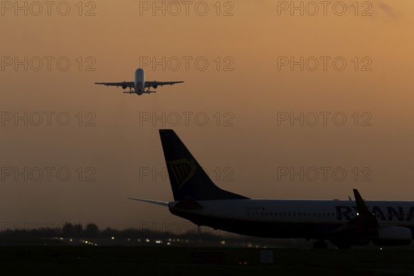 Airbus commercial passenger airliner jet aircraft taking off in flight at sunset at London Stansted airport, Essex, England, United Kingdom
