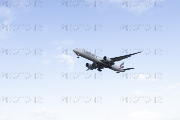 Boeing 777 commercial passenger airliner jet aircraft of Emirates airways in flight on approach to London Stansted airport, Essex, England, United Kingdom