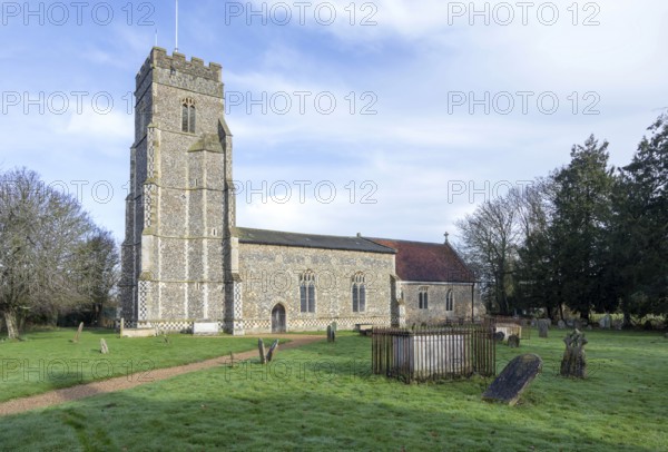 Village parish church of Saints Peter and Paul and its rural churchyard with gravestones, Pettistree, Suffolk, England, UK