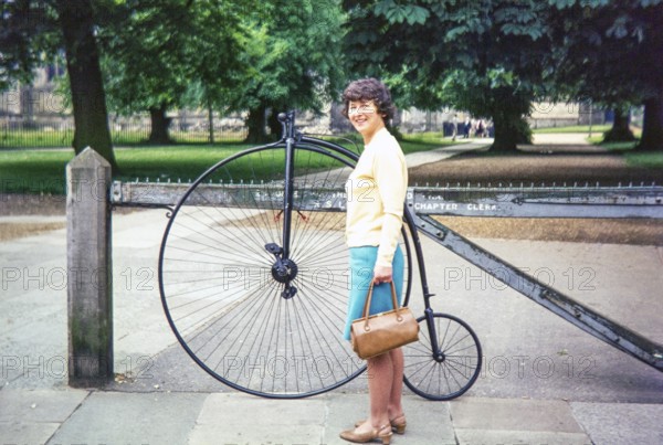 Woman standing by penny-farthing bicycle, Durham Cathedral, Durham, England, UK 1970s