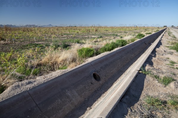 Buckeye, Arizona - A an empty concrete irrigation ditch runs next to an unused field on a farm in the Arizona desert. Water availability is an increasing problem as drought affects the western U.S