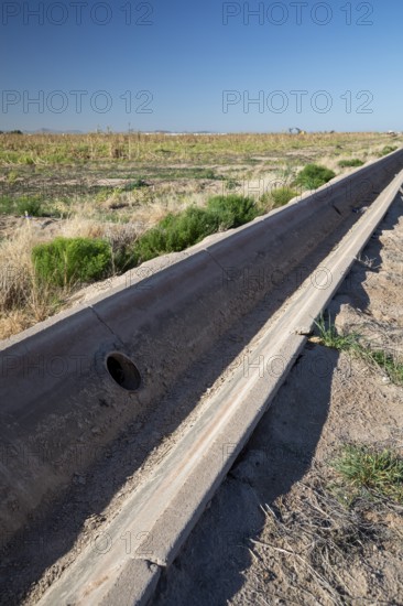 Buckeye, Arizona - A an empty concrete irrigation ditch runs next to an unused field on a farm in the Arizona desert. Water availability is an increasing problem as drought affects the western U.S