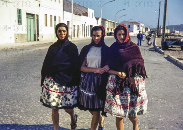 Three young women teenage girls wearing traditional clothes dressed in shawls and headscarfs, Nazare, Portugal, Europe 1968