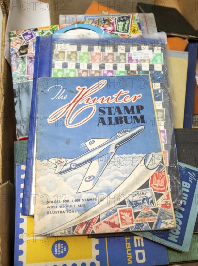 Stamps albums and stamp collection assembled in box, 1950s album with picture of Hawker Hunter RAF jet aircraft, UK