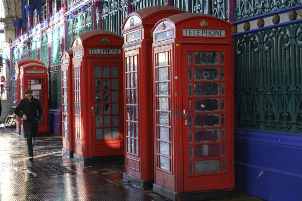 London, UK. January 30th 2025. A man walks past a row of old fashioned telephone boxes in Smithfield Market, the largest wholesale meat market in the UK