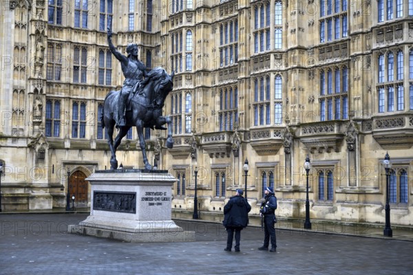 London, UK. January 31st 2025. Two British policemen admire the statue of Richard I on horseback, also known as Richard the Lionheart stands in Old Palace Yard, Houses of Parliament in Westminster, London, UK