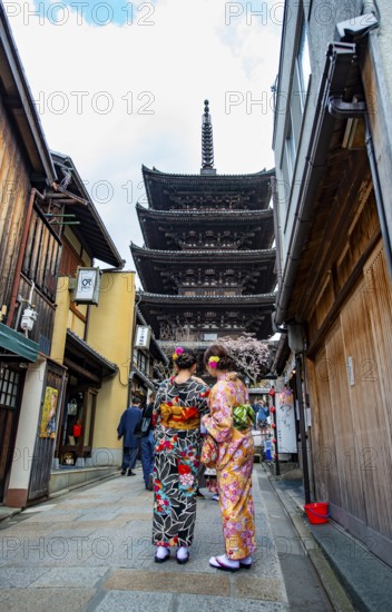 Two Japanese woman in kimonos in an alley, at the back five-story Yasaka Pagoda of the Buddhist Hokanji Temple, Higashiyama, Kyoto, Japan