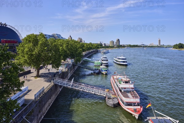 Rhine river, general architecture, Zoobrücke car bridge, footpath and cycle path, waterfront, boat launch, gangway, wharf, excursion boats, pedestrians as accessories, trees, bird's-eye view, blue sky, cirrus clouds, potion yard, Cologne, district-free city, North Rhine-Westphalia, Germany