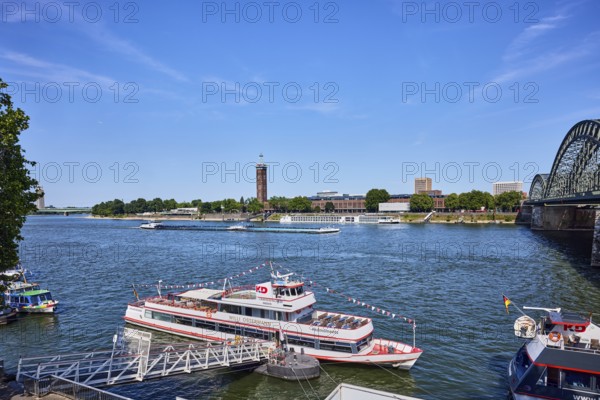 Rhine river, Hohenzollernbrücke pedestrian and railway bridge, excursion ship Willi Ostermann, Cologne-Düsseldorfer Deutsche Rheinschiffahrt GmbH, gangway, wharf, general architecture, high-rise buildings, exhibition tower, paddock, blue sky, cirrus clouds, Trankgassenwerft, Cologne, district-free city, North Rhine-Westphalia, Germany