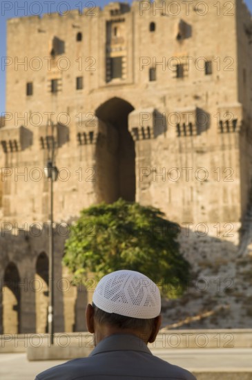 Aleppo, Syria. September 5th 2010 An old Syrian man sits in front of the entrance to the Citadel of Aleppo, Syria