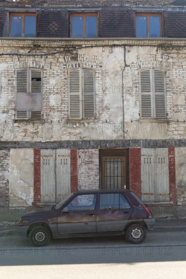 A popular old French car parked outside a typical rural French house in a countryside village in the Burgundy region of France