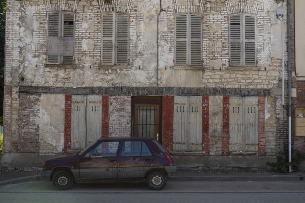 A popular old French car parked outside a typical rural French house in a countryside village in the Burgundy region of France