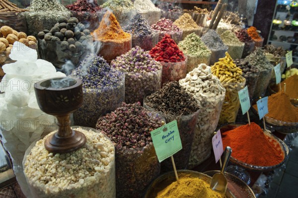 Dubai, United Arab Emirates. July 1st 2019 Incense burning alongside coloured spices for sale in Dubai Creek Souk, UAE