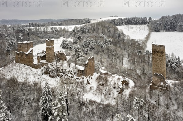 Ruins of an old castle in the snow with surrounding trees and hilly backdrop, The Brandenburg in the Werra Valley near Eisenach