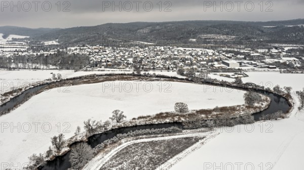 Snowy river landscape with villages and hills under a grey sky, Herleshausen in North Hesse