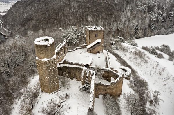 Old castle ruins with snow-covered towers and walls on a hill, The Brandenburg in the Werra Valley near Eisenach