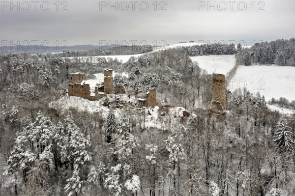 Snowy castle ruins in a wooded winter landscape, surrounded by rolling hills, The Brandenburg in the Werra Valley near Eisenach