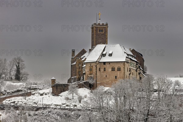 Castle in snow under cloudy sky, no vegetation visible in the foreground, The Wartburg near Eisenach in Thuringia