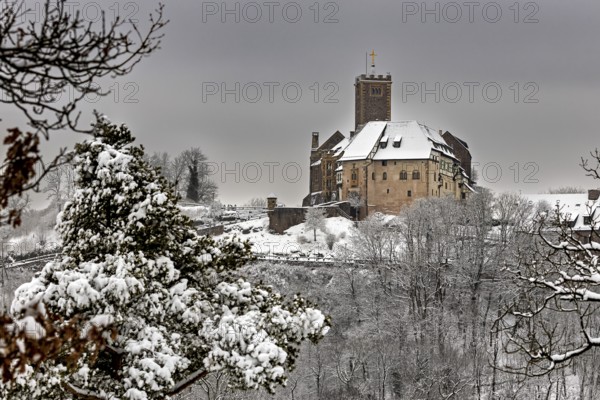 Medieval castle in winter with snow-covered forest and cloudy sky, The Wartburg near Eisenach in Thuringia