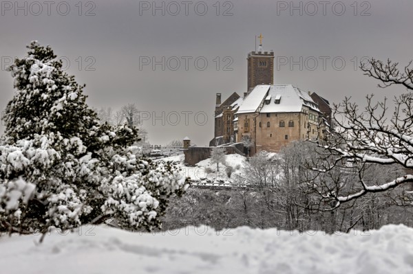 Medieval castle in winter with snow-covered landscape and cloudy sky, The Wartburg near Eisenach in Thuringia