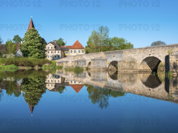 The Stone Bridge, medieval stone bridge over the Wörnitz river near the small village of Ebermergen with perfect reflection, Harburg, Swabia, Bavaria, Germany