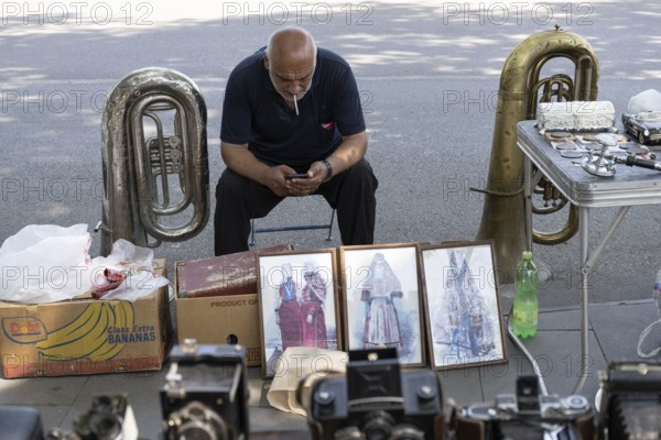 Tbilisi, Georgia. July 11th 2025. Street stall vendor at the Dry Bridge Flea Market selling antiques and old Soviet memorabilia in Tbilisi Old Town near the River Kura