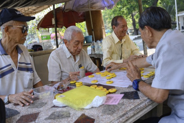 Bangkok, Thailand. March 4th 2025. Old men play Chinese board games on a Sunday morning in Lumphini Park, Bangkok