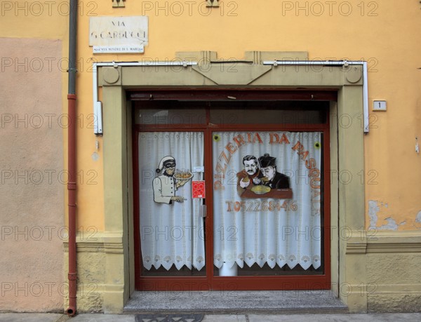 Italy, village of Brescello, advertisement for Pizzeria Pasquale, with a picture of Don Camillo and Peppone
