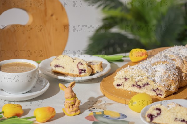 Breakfast table with coffee, sliced yeast braid and decoration for Easter