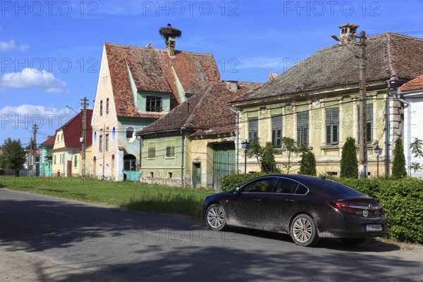 Typical rural houses in the old village of Dealu Frumos, Schönberg, in front of that an Opel Insigna car, Transylvania, Romania