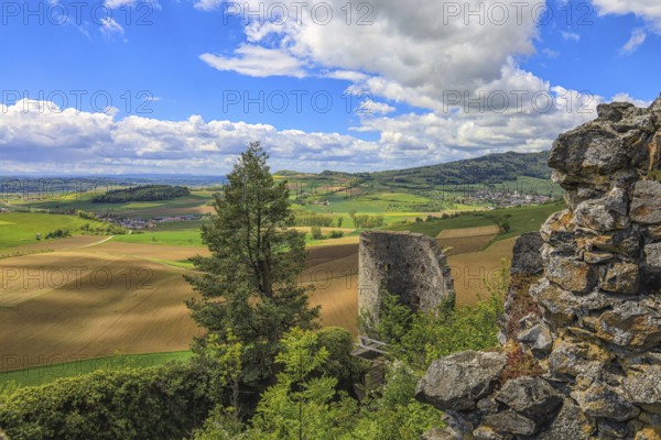 Ruins in front of a wide view of fields and hills under a cloudy blue sky, Mägdeberg Castle Ruins, Mühlhausen-Ehingen, Hegau, Hegau Volcanic Landscape, Konstanz District, Baden-Württemberg, Germany