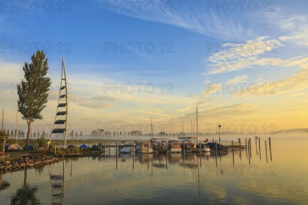 Lake Zell at sunrise with boats on a jetty and a clear sky with clouds, Lake Constance, Höri peninsula, moss, Radolfzell, Konstanz district, Baden-Württemberg, Germany