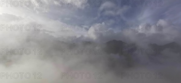 Thick blanket of clouds and fog over a mountain landscape with mystical sky, hiking in the High Tatras National Park, Carpathian Mountains, Poland