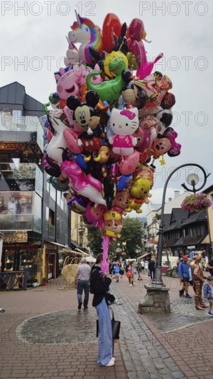 Large group of colorful balloons in the form of comic figures, children's toys on a road, Zakopane, hiking in the High Tatras National Park, Carpathian Mountains, Poland