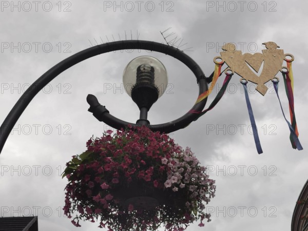 Decorative street lamp with flowers and a heart under cloudy sky, Zakopane, hiking in the High Tatras National Park, Carpathian Mountains, Poland