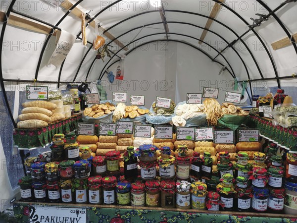 Colourful market stand with various types of jams and breads and local specialities under a tent, Zakopane, hiking in the High Tatras National Park, Carpathian Mountains, Poland