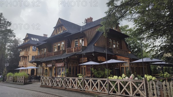 Charming restaurant in traditional Zakopane Tatra wood style with terrace and garden fence, Zakopane, High Tatras National Park, Carpathian Mountains, Poland