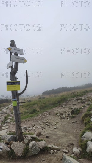 Rocky trail with signposts and fog landscape, Zakopane, hiking to Kasprowy Wierch in the High Tatras National Park, Carpathian Mountains, Poland