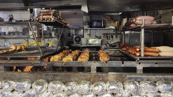 Large grill with various meats and local specialties over an open fire in a kitchen, Zakopane, hiking in the High Tatras National Park, Carpathian Mountains, Poland