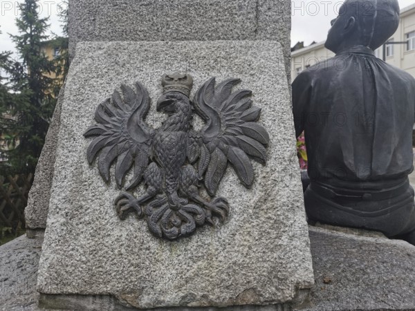 Stone monument with relief of the Polish white eagle, next to a human sculpture, Zakopane, hiking in the High Tatras National Park, Carpathian Mountains, Poland