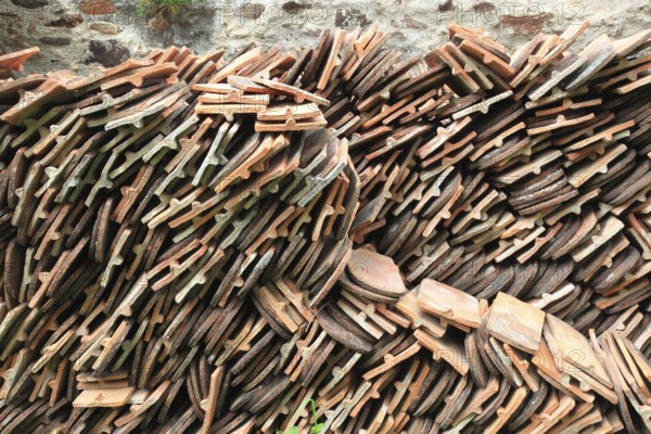 Old roof tiles stored on stockpiles for reuse on historic buildings and heritage-protected houses, beaver tail tiles, clay tiles