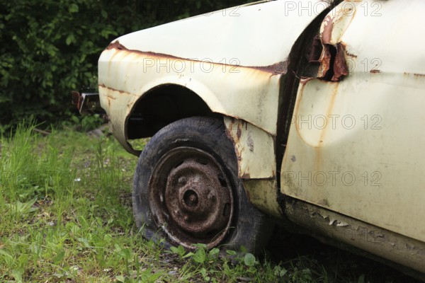 Car wreck, flat tire on rusty rim, rust, junk car