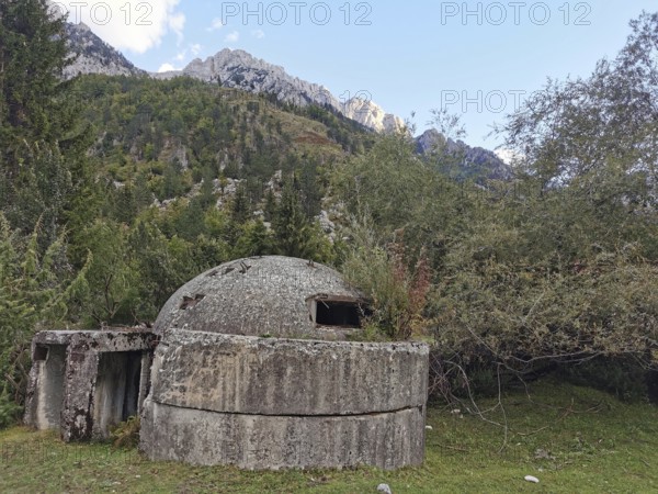 Concrete bunker in a wooded mountainous landscape, a relic from the past, Hoxha, dictatorship, Peaks of the Balkans, hiking in the Albanian Alps National Park, Albania