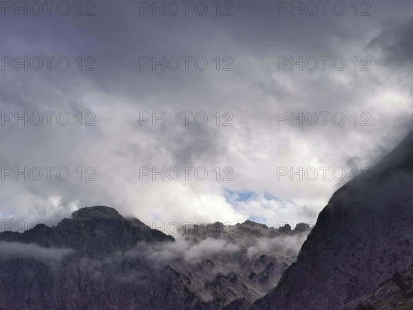 Dark, dramatic clouds over jagged mountain peaks creating a majestic scene, Peaks of the Balkans, hiking in the Albanian Alps National Park, Albania